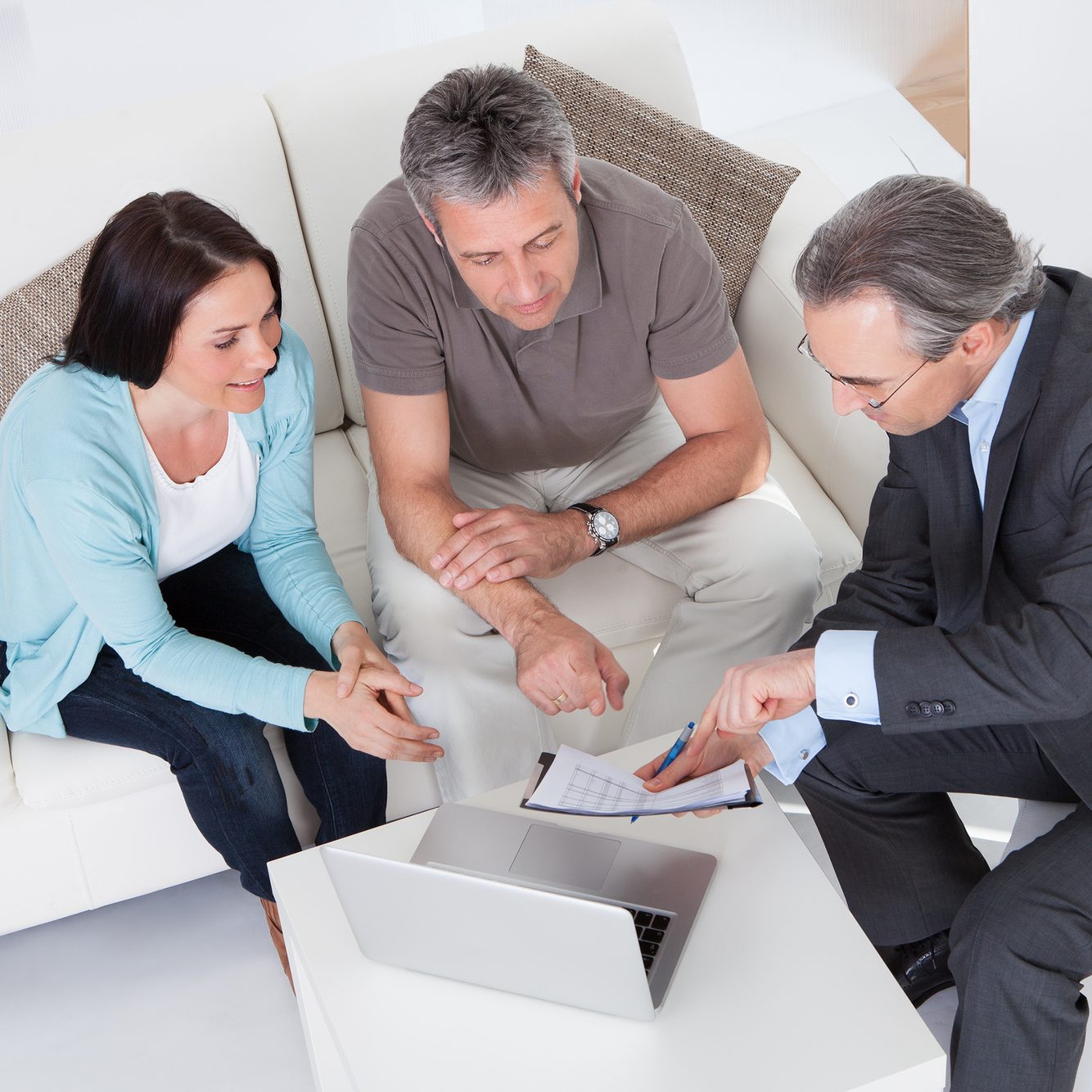 Happy Couple And Mature Consultant Discussing Together